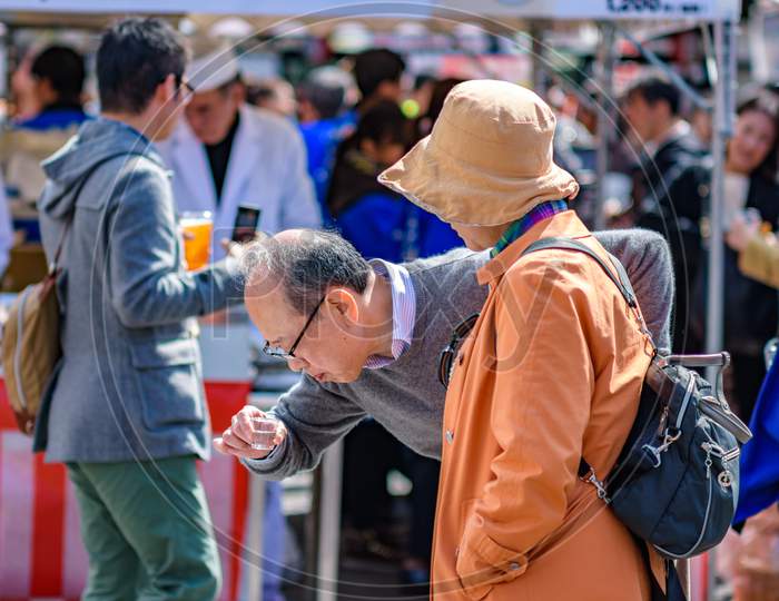 People Tasting Sake At A Local Brewery In Kyoto, Japan