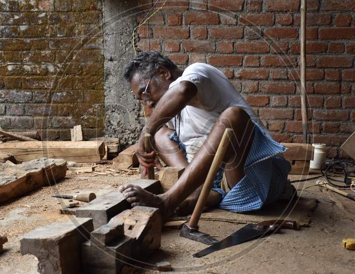 A Carpenter Working On Wood By Using Traditional Tools
