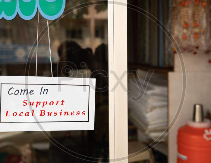 Come In Support Local Business Signage Attached In front Of Door During Coronavirus Or Covid-19 Pandemic To Support Local Community.
