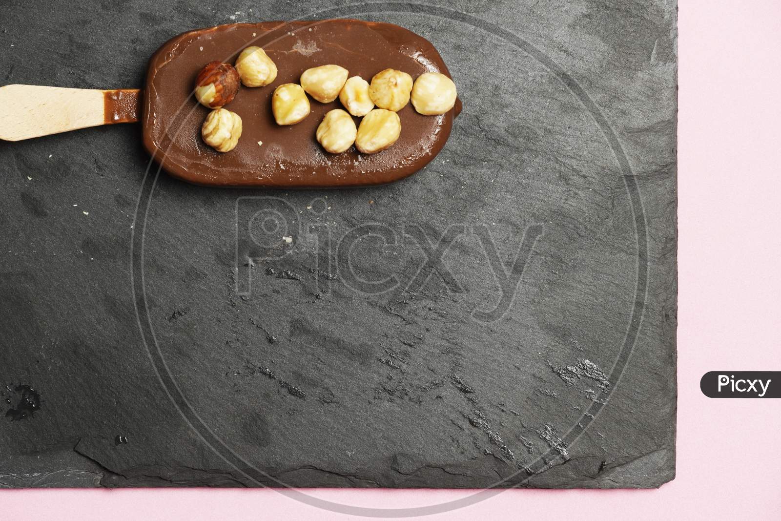 Chocolate Ice Cream With Organic Hazelnuts On Dark Slate Background. Flat Lay. Gastronomic Food