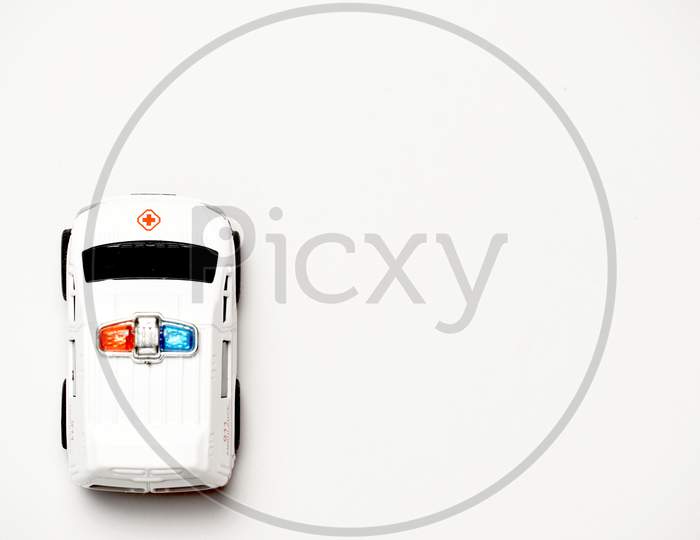 Toy Ambulance On White Background With Copy Space. Flat Lay .Flat Design. Concept Of Traveling By Car