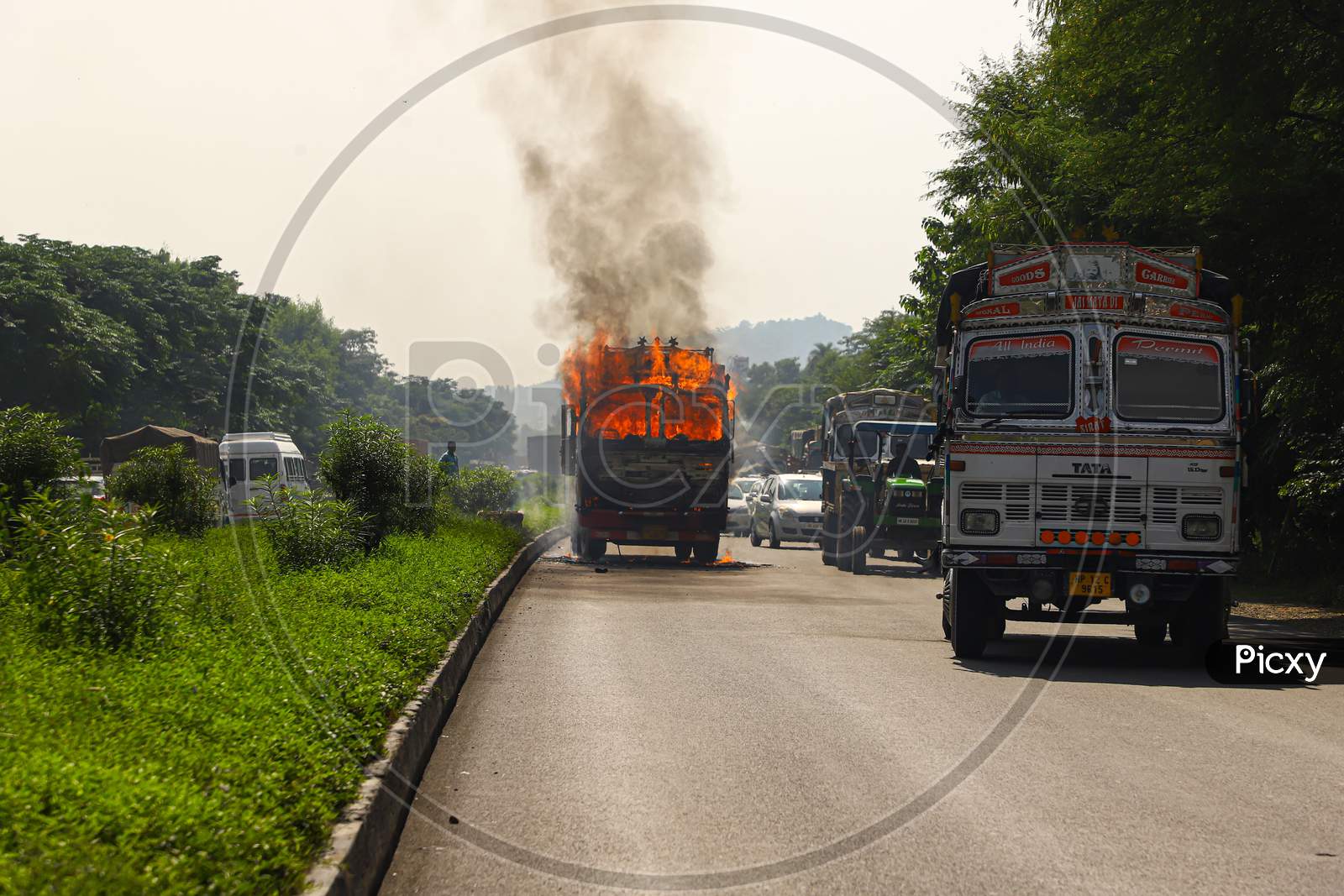Fire and black smoke on the road after a truck collision