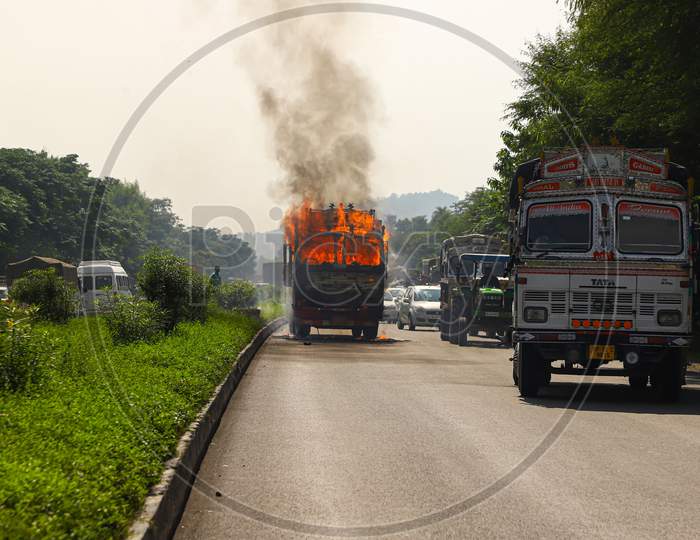 Fire and black smoke on the road after a truck collision