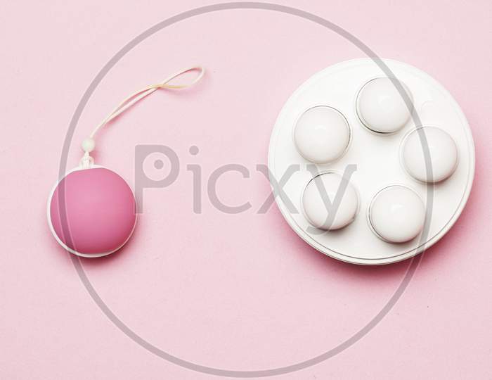 Pelvic Floor Weight And Ball On A Pink Background. Flat Lay. Flat Design. Feminine Intimate Care Concept
