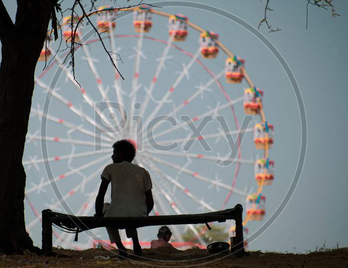 unedentified man and ferris wheel  at pushkar camel festival at rajasthan