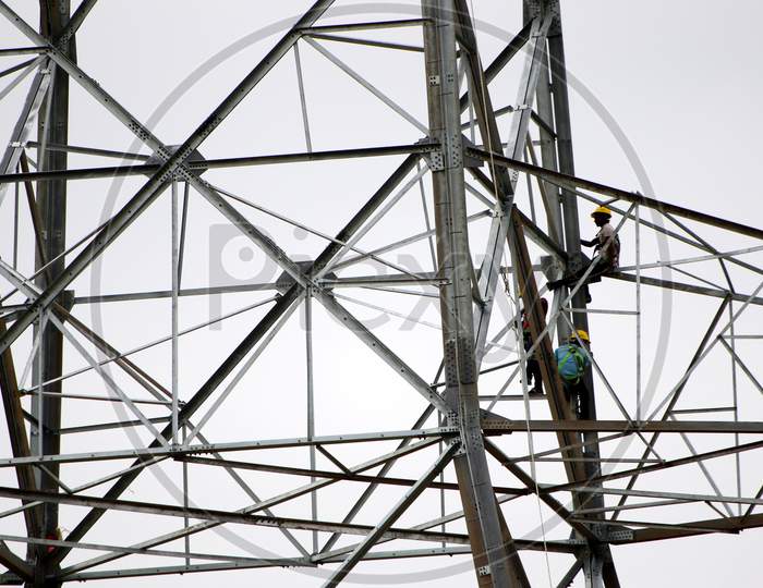 Indian workers install a new electric pole for power lines on the outskirts of Ajmer on August 23, 2020.