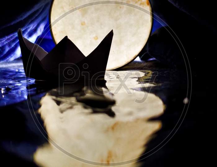 Boat in a water illusion of moon backlit