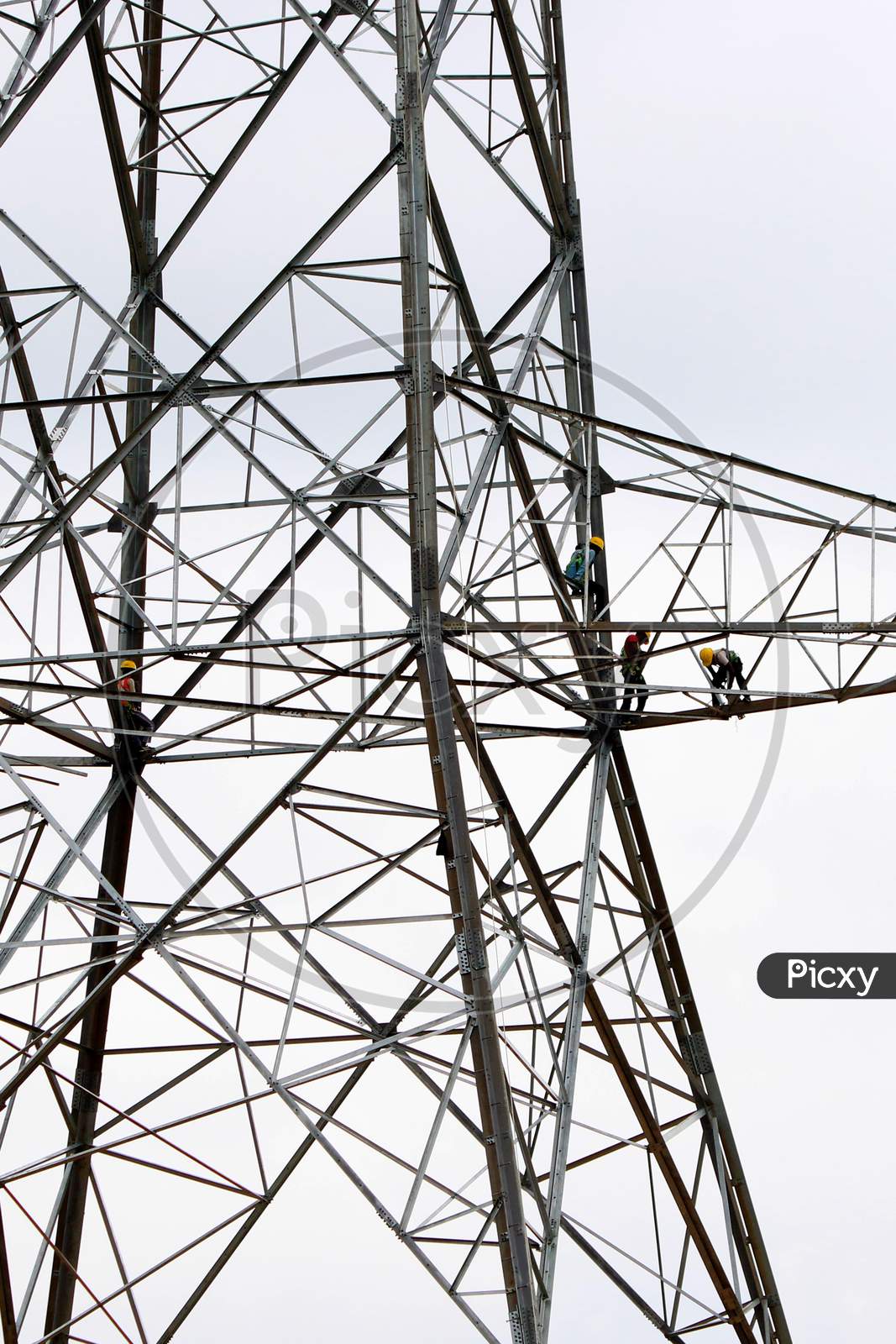 Indian workers install a new electric pole for power lines on the outskirts of Ajmer on August 23, 2020.