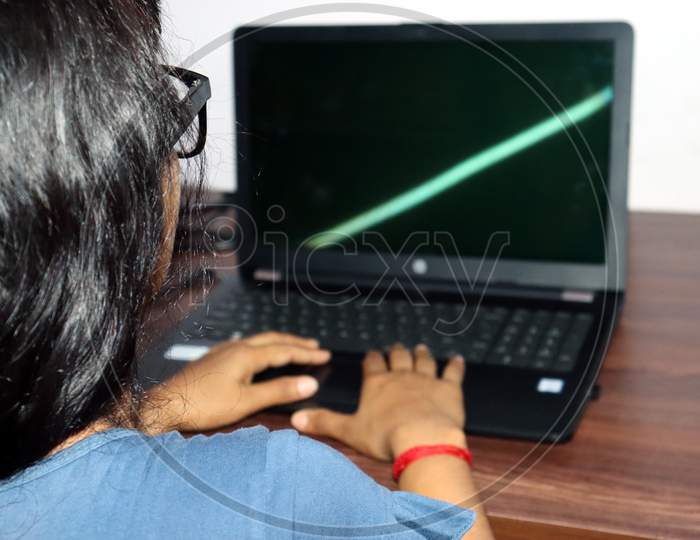 A Girl Working On Laptop From Home Backside View
