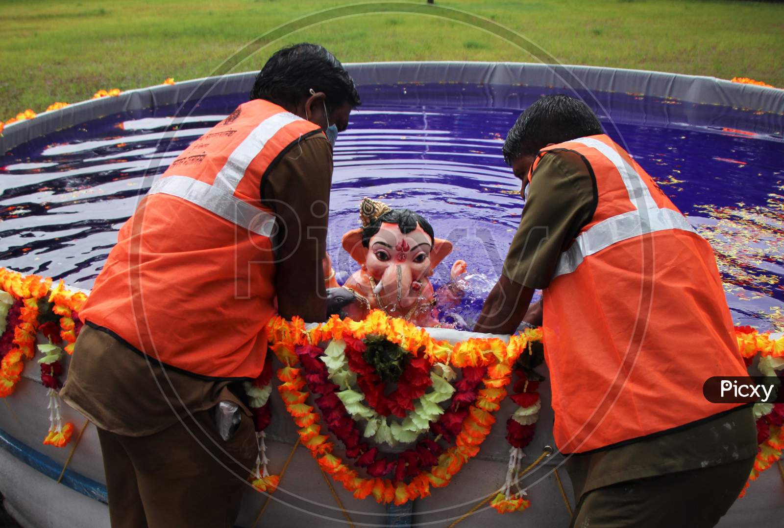 Bmc people immerses an idol of the Hindu god Ganesh, the deity of prosperity, in an artificial pond during the Ganesh Chaturthi festival in Mumbai, India, August 23, 2020.