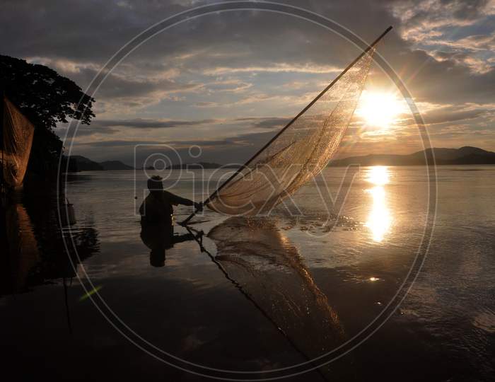 A Fisher Man Fishing At The Banks Of River Brahmaputra During The Sunset In Guwahati On Sunday, Aug 23 2020.