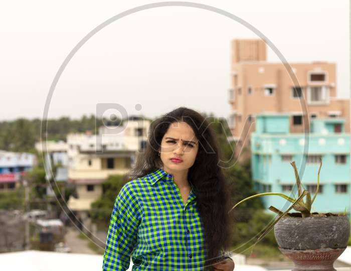 A Beautiful Indian Woman And Wearing A Green Shirt And The Back Of Chennai City Blur Background