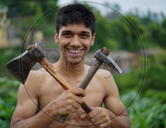 Young Handsome Shirtless Boy Holding Axe In His Hands.