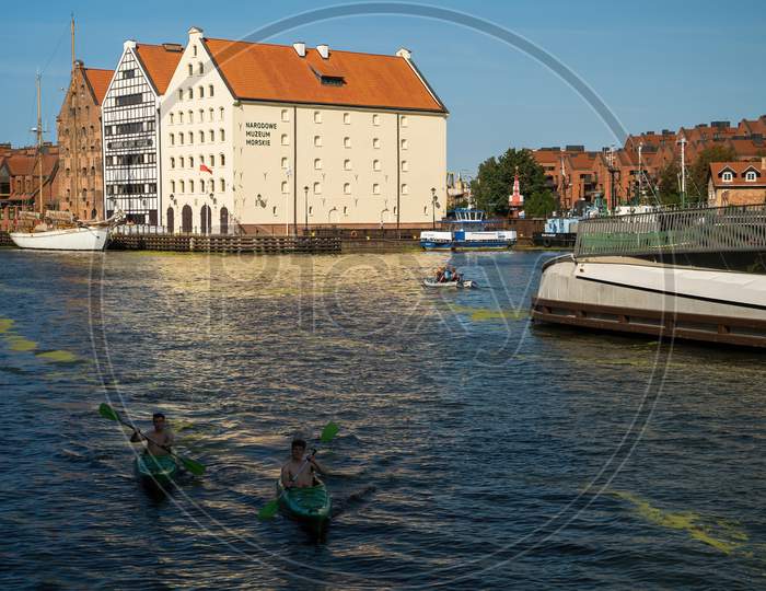 Gdansk, North Poland - August 13, 2020: Wide Angle Shot Of Summer And People Kayaking In Motlawa River Adjacent To Beautiful European Architecture Near Baltic Sea