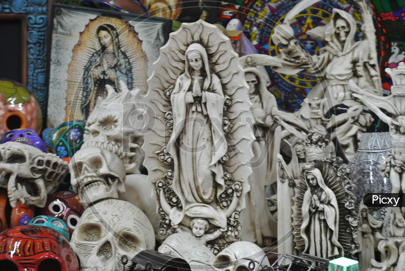 Statue Of The Virgin Mary Along With Skull And Other Carvings In A Souvenir Shop In Mexico