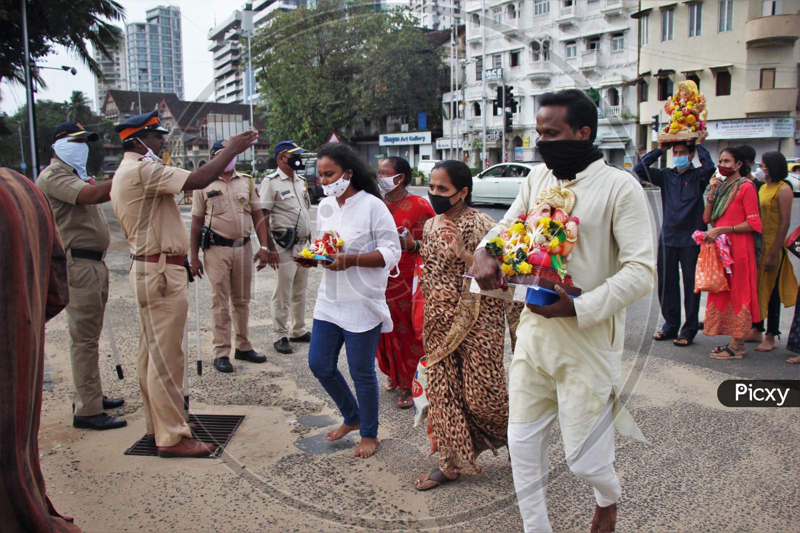 Police personnel are seen ensuring that only two family members with an idol enter for ganesh immersion at Girgoan Chowpatty, during the Ganesh Chaturthi festival in Mumbai, India on August 23, 2020.