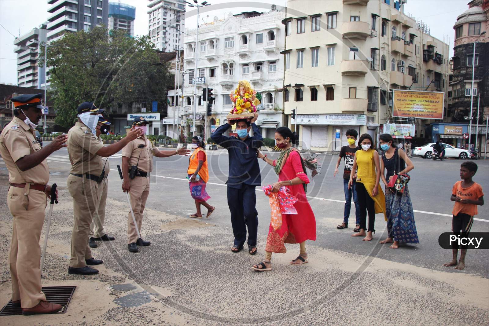 Police personnel are seen ensuring that only two family members with an idol enter for ganesh immersion at Girgoan Chowpatty, during the Ganesh Chaturthi festival in Mumbai, India on August 23, 2020.