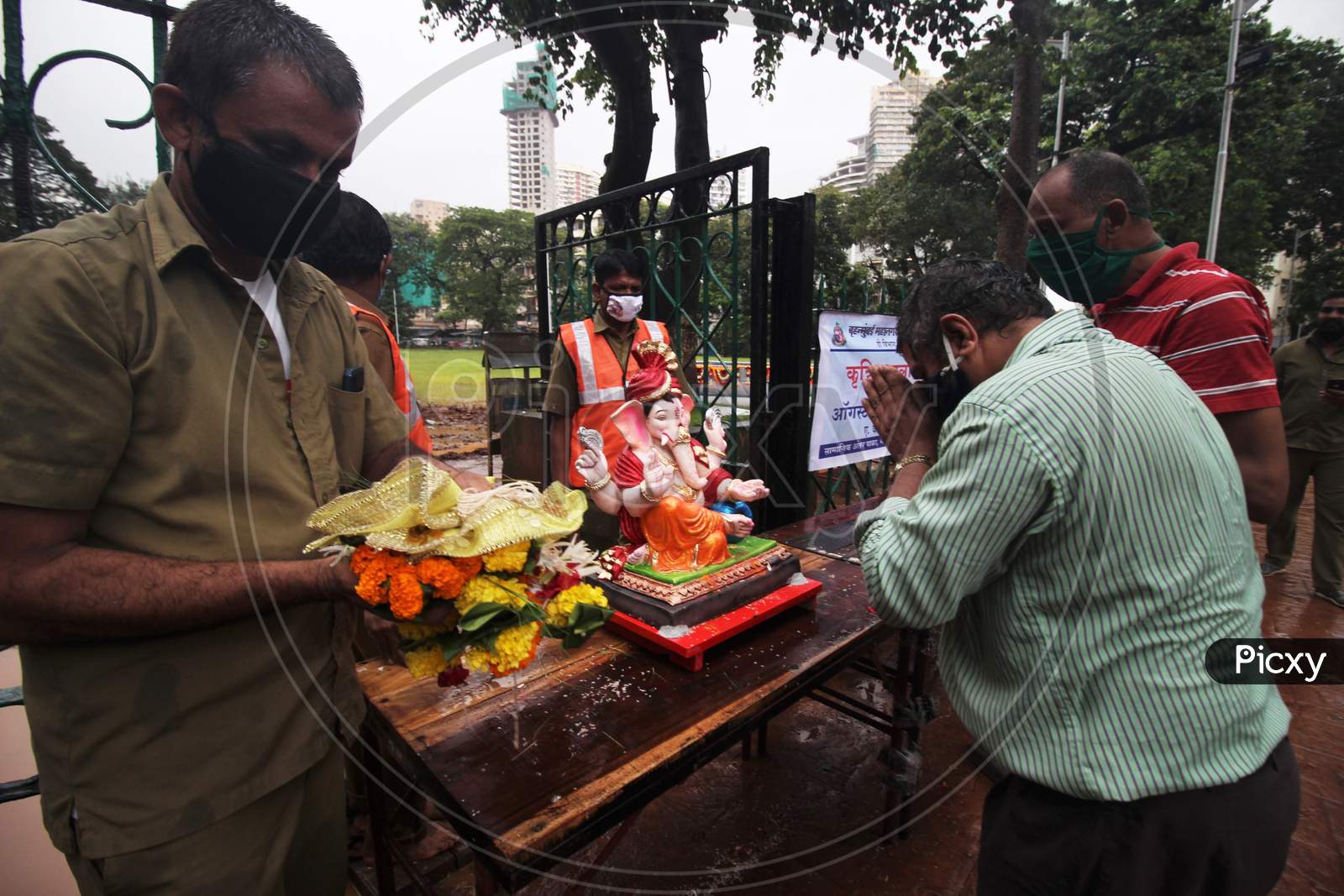 Devotees pray to a clay idol of Hindu elephant-headed deity Ganesh, before immersing it in an artificial pond, in Mumbai, India on August 23, 2020.