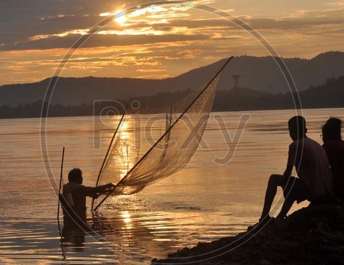 A Fisherman catches fish At The Banks Of River Brahmaputra During The Sunset In Guwahati On Sunday, Aug 23 2020.