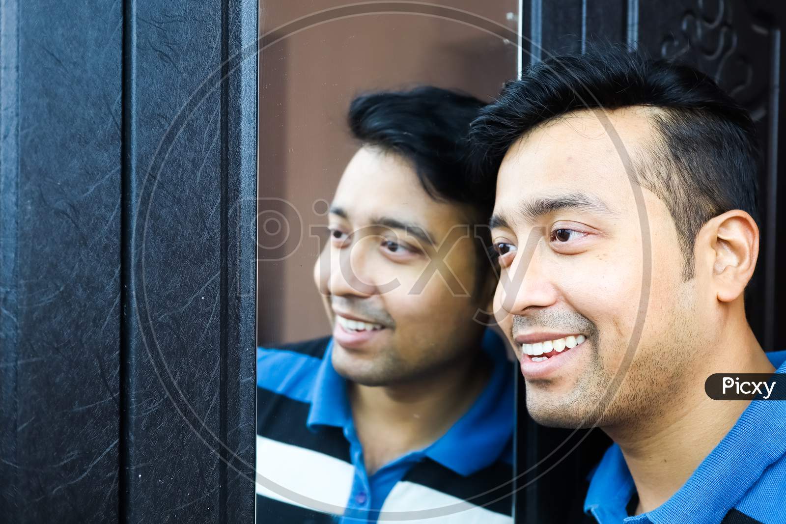 A Man I And His Reflection In Mirror Smiling In Happy Mood
