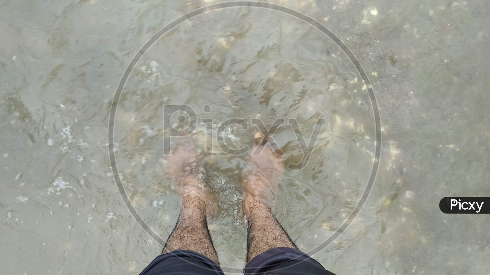 24 august 2020 india; A man is standing in the river's water enjoying the cold water