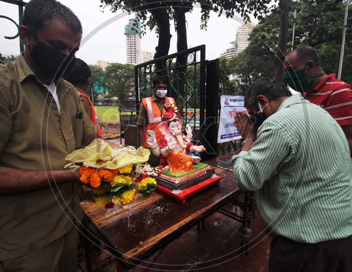 Devotees pray to a clay idol of Hindu elephant-headed deity Ganesh, before immersing it in an artificial pond, in Mumbai, India on August 23, 2020.
