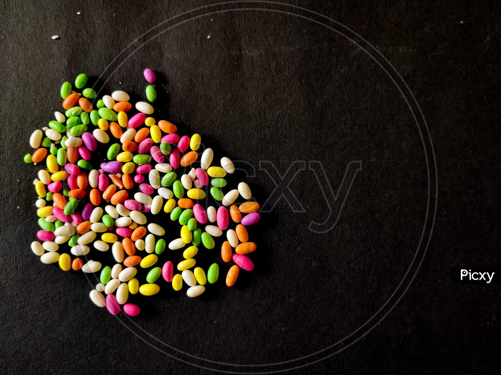 Scattered Colored Candies Or Chocolates Isolated On Black Background.