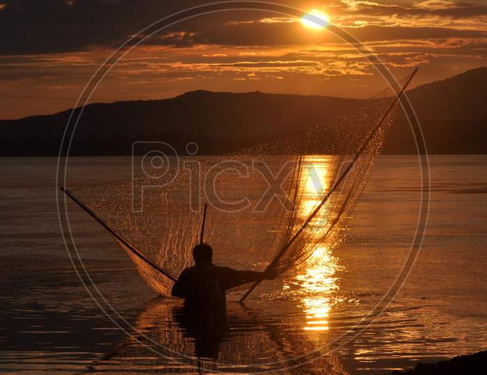 A Fisher Man Fishing At The Banks Of River Brahmaputra During The Sunset In Guwahati On Sunday, Aug 23 2020.