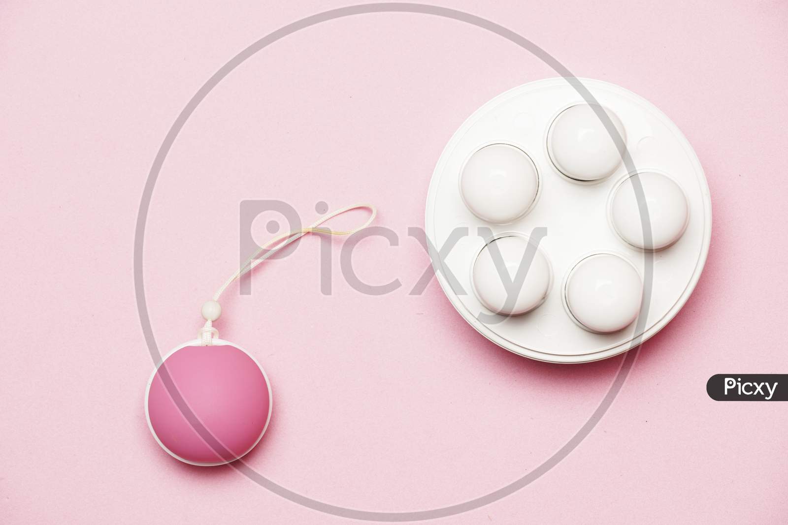 Pelvic Floor Weights And Ball On A Pink Background. Female Health Care Concept. Flat Lay