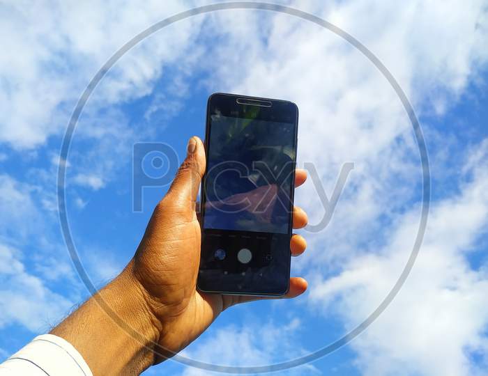 Leaf Hand Holding A Smartphone Towards The Sky