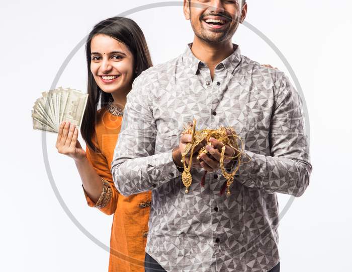 Indian Young Couple Holding Gold Jewelry Or Ornaments In Hand