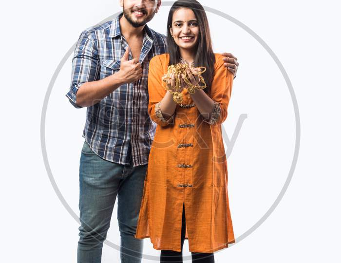 Indian Young Couple Holding Gold Jewelry Or Ornaments In Hand