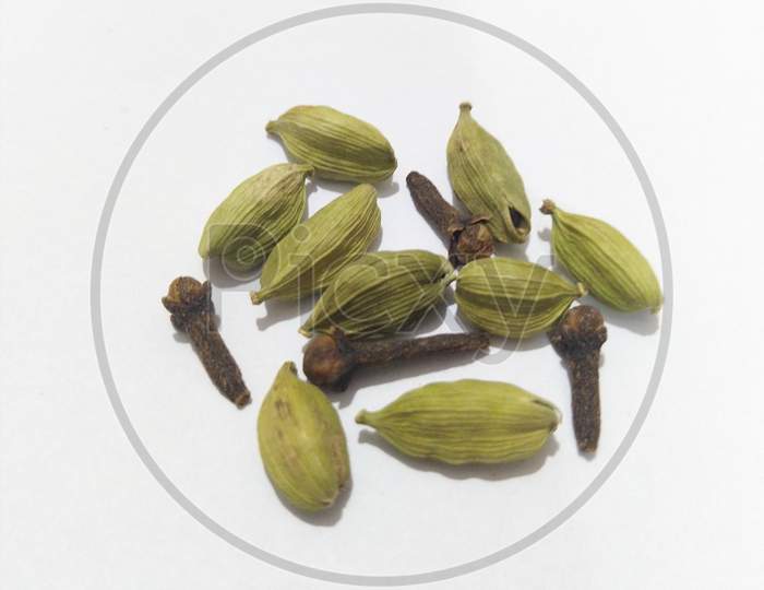 Cardamoms and cloves isolated on white background.