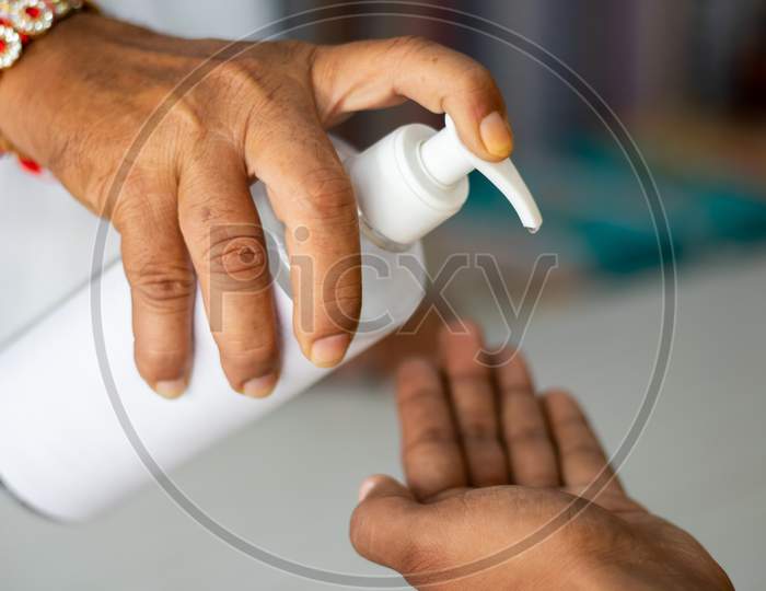 Close Up Of Shopkeeper Hands Giving Sanitizer To Customer To Stop Spreading Coronavirus Or Covid-19 Infection - Concept Of Safety, Hygiene Measures At Business And Workplace.