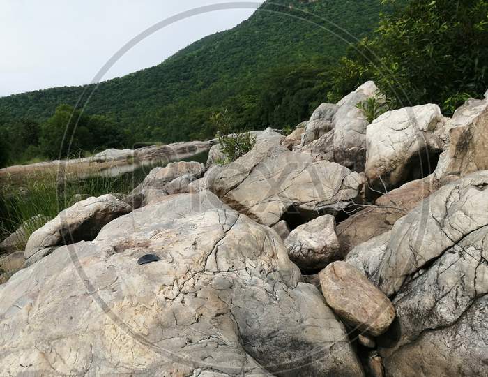Huge rock lying on the side of the riverbed of mountain.
