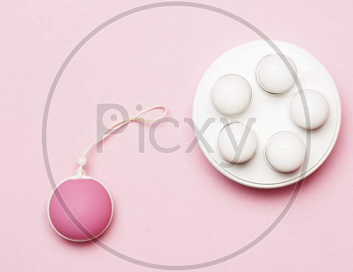 Pelvic Floor Weights And Ball On A Pink Background. Female Health Care Concept. Flat Lay