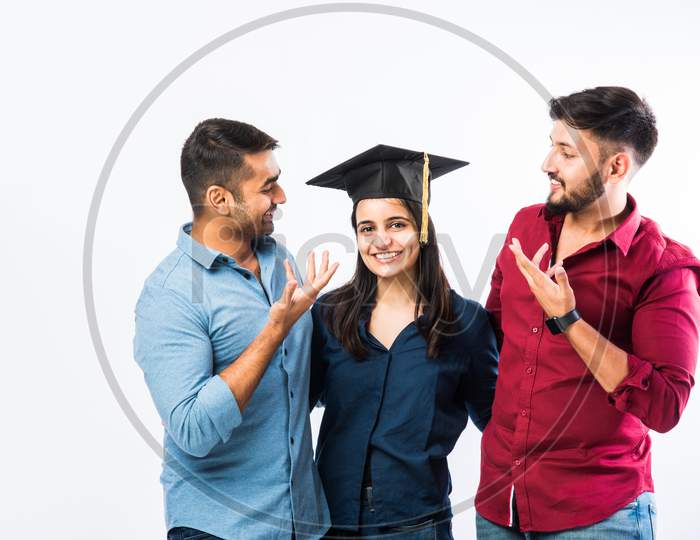 Indian Graduate Female Student Wearing Hat Celebrating Success With Male Friends
