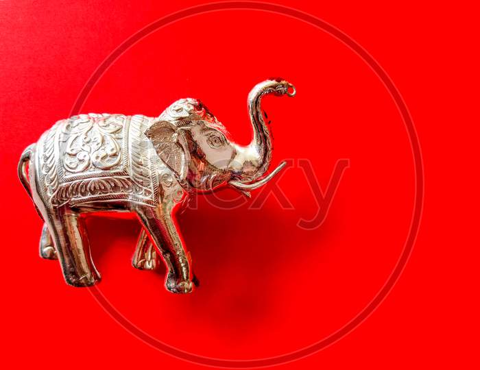 Silver Color Elephant Toy Isolated On Red Background.