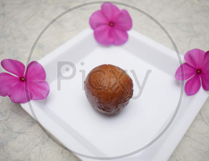 Gulab Jamun A Dessert Often Eaten At Festivals, Celebrations In Indian Subcontinent. Single Piece Close Up Of A Sweet On White Plate In White Background