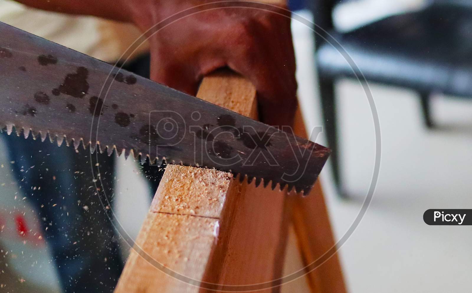 An Wooden Door Being Cut By A Saw Manually