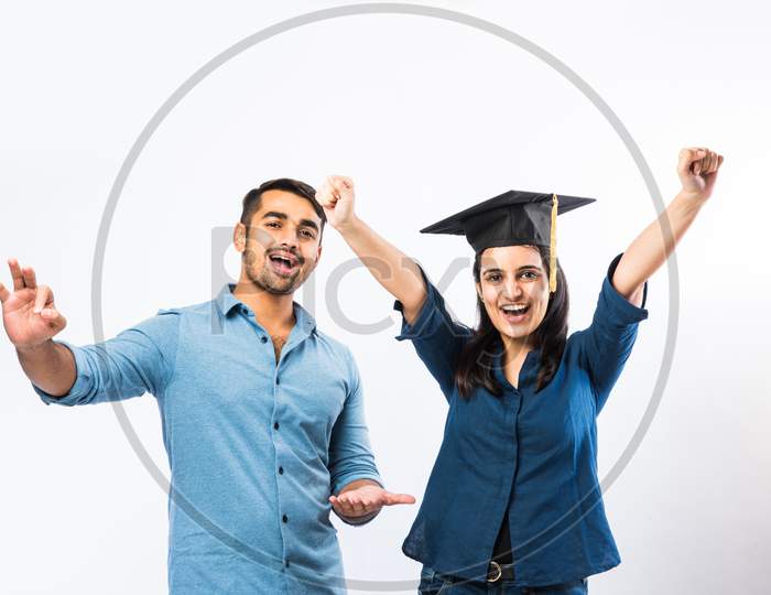 Indian Graduate Female Student Wearing Hat Celebrating Success With Male Friends