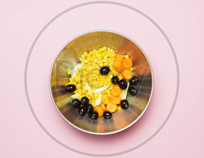 Top View Of Summer Or Spring Salad With Black Olives, Corn And Other Vegetables. Gastronomic Food. Flat Lay Flat Design