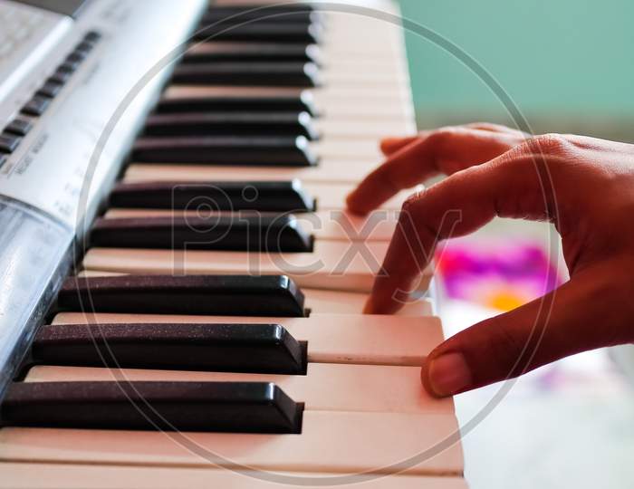 Hands Of Musician Playing Piano. View From Side