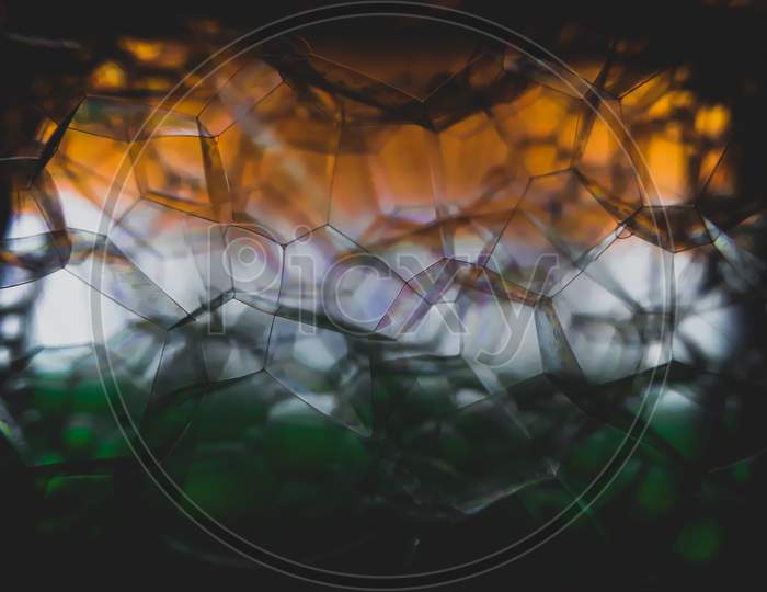 Soap bubble shapes into focus with Indian flag background.