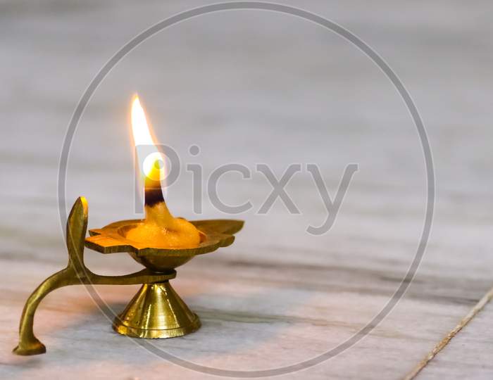 A Brass Oil Lamp Being Lit At A Temple During Worship