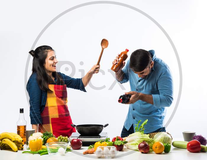Indian Couple Cooking - Attractive Wife And Handsome Husband In Kitchen With Fresh Green Vegetables