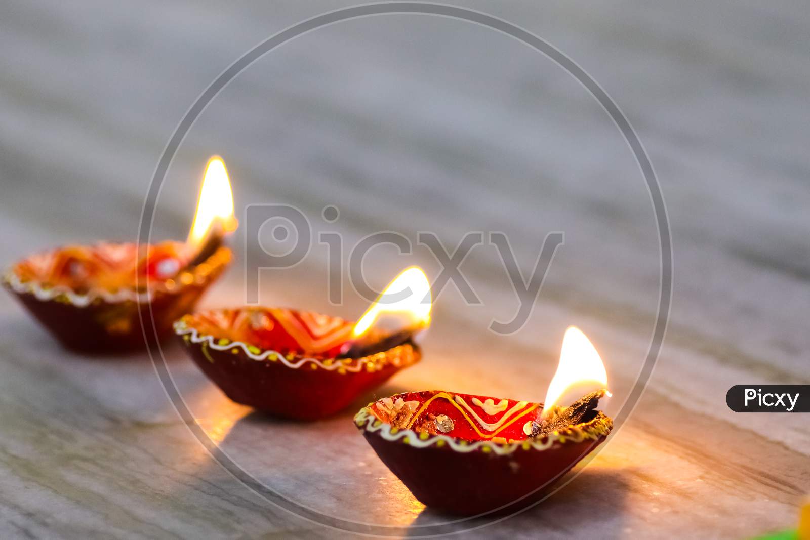 A Set Of 3 Earthen Oil Lamp Being Lit At A Temple During Worship