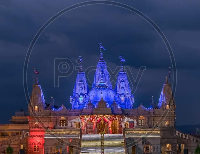 Lighted Image Of Shree Swaminarayan Temple With Monsoon Clouds Background, Pune.