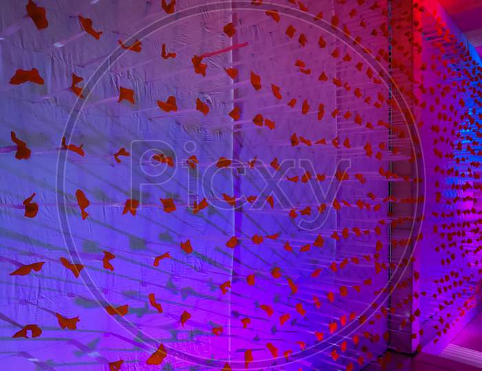 Wall Decoration With Blue Light Effect And Red Flowers.