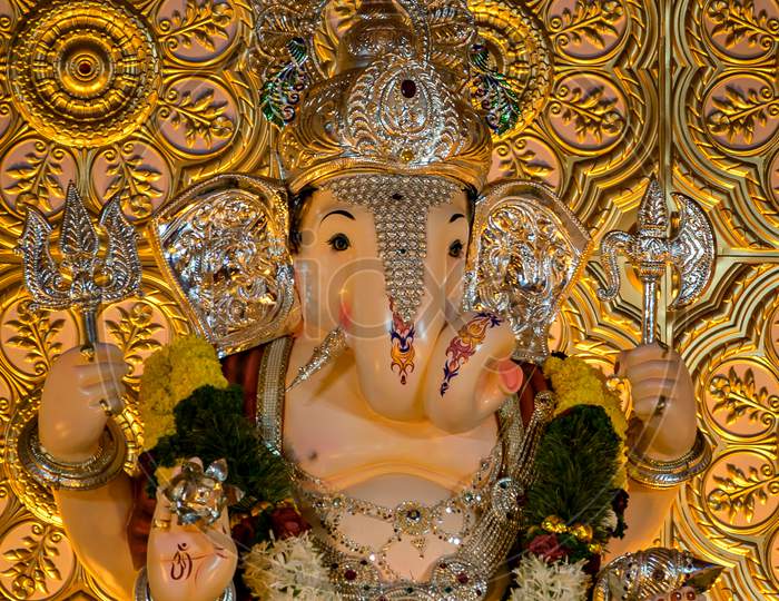 Closeup View Of Decorated And Garlanded Isolated Idol Of Hindu God Ganesha.